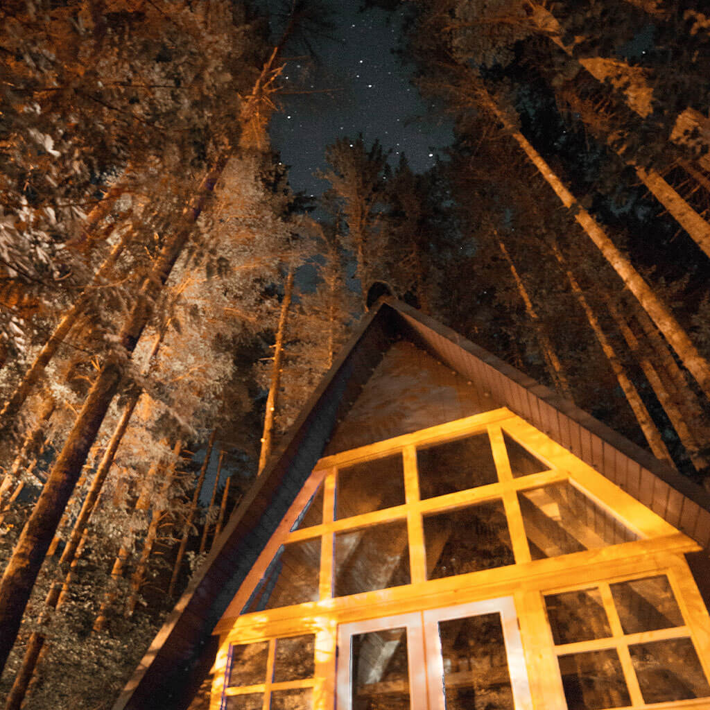 A-Frame Cabin with trees and starry night sky