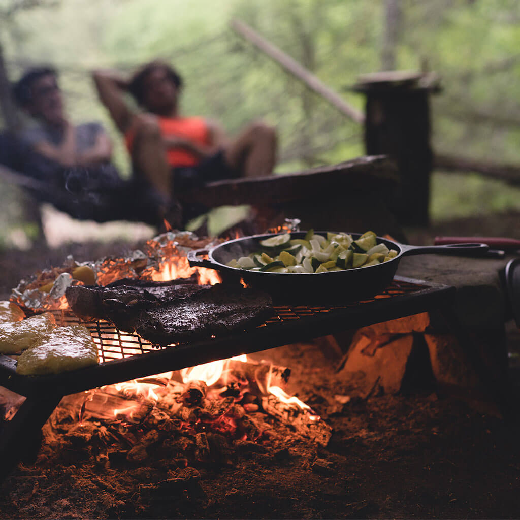 dinner being cooked over a campfire