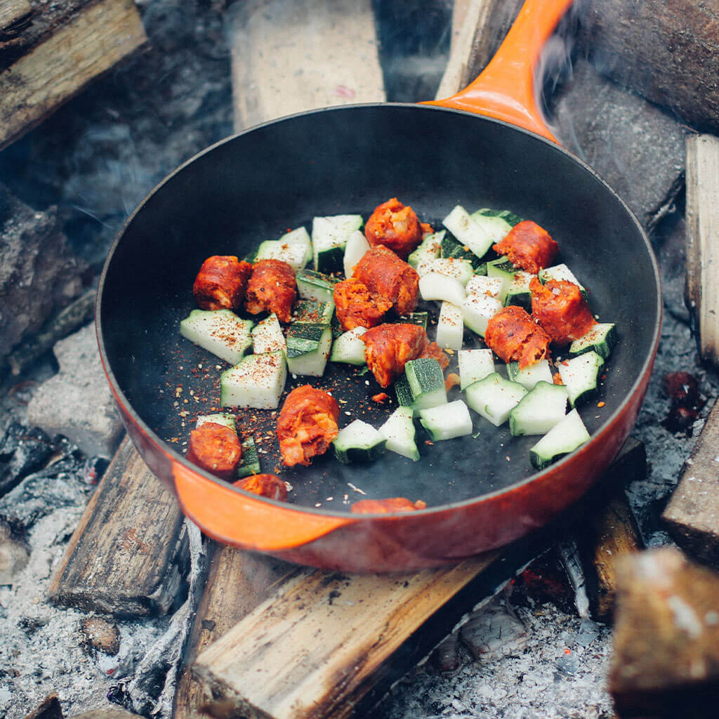 Mixed vegetables in skillet over campfire.