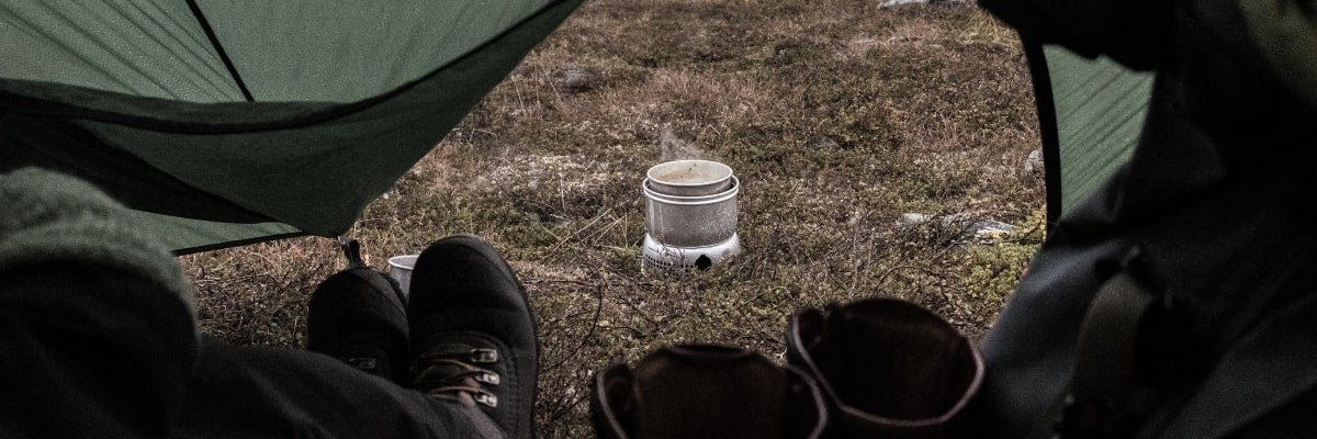 Camper watching his gumbo cook from his tent.