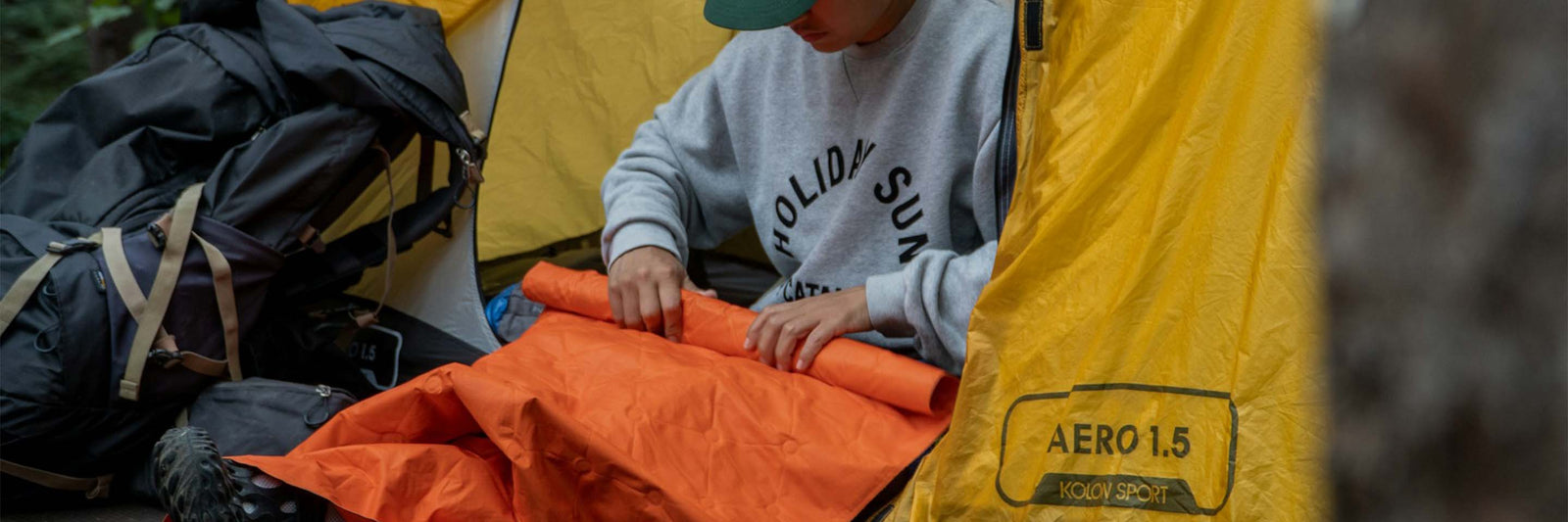 Camper rolling up sleeping pad.