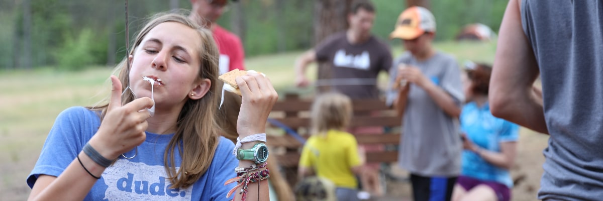 Happy campers enjoying delicious s'mores desserts.