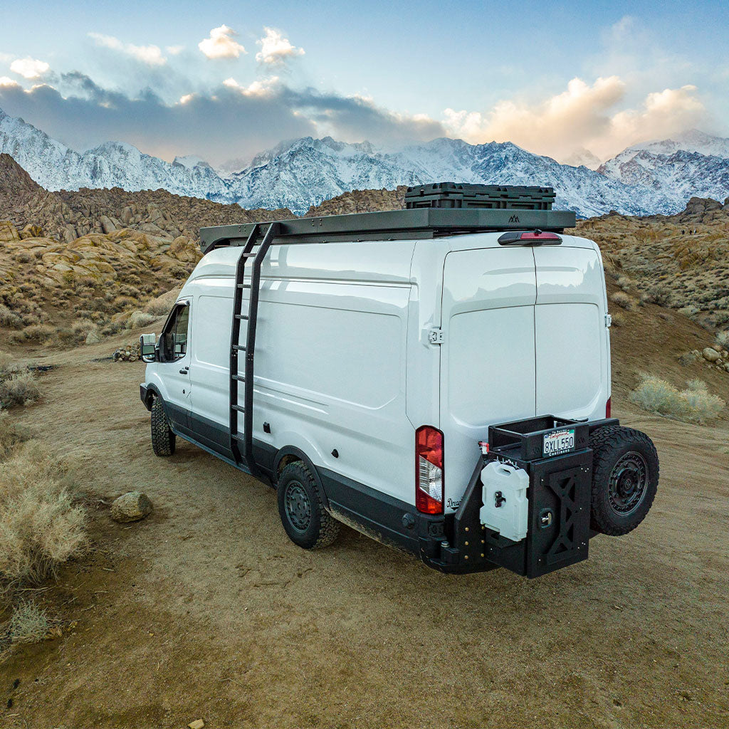 White campervan parked in desert in front of mountain range