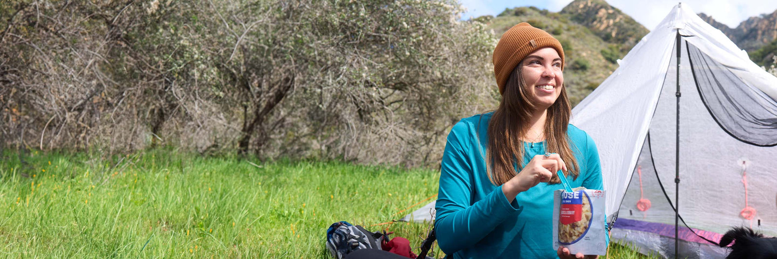 Woman enjoying a high-protein camping meal.