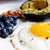 fried egg, blueberries, avocado and nuts and white plate