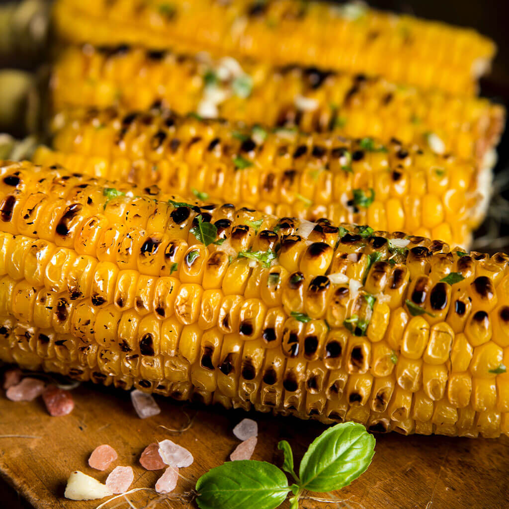 four pieces of grilled corn