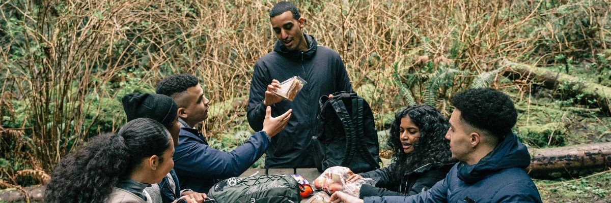 Two hikers eating healthy snacks.