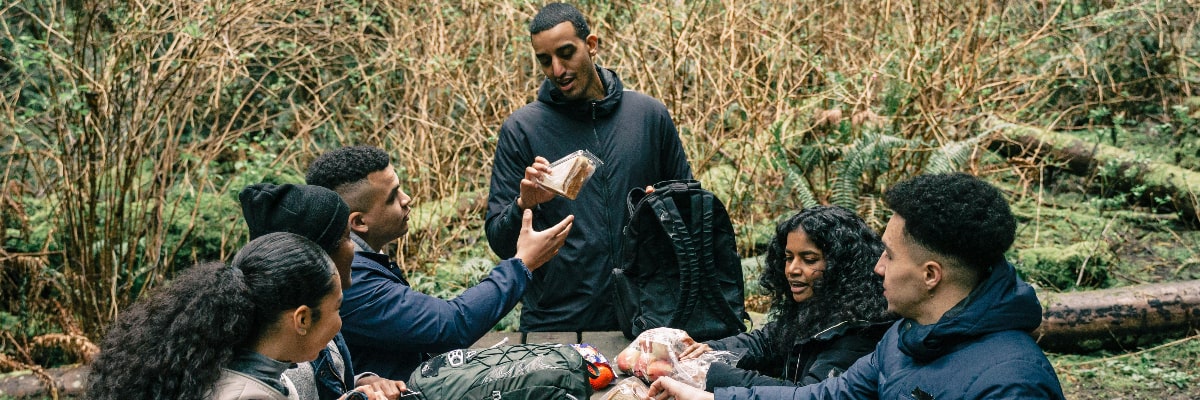 Two hikers eating healthy snacks.