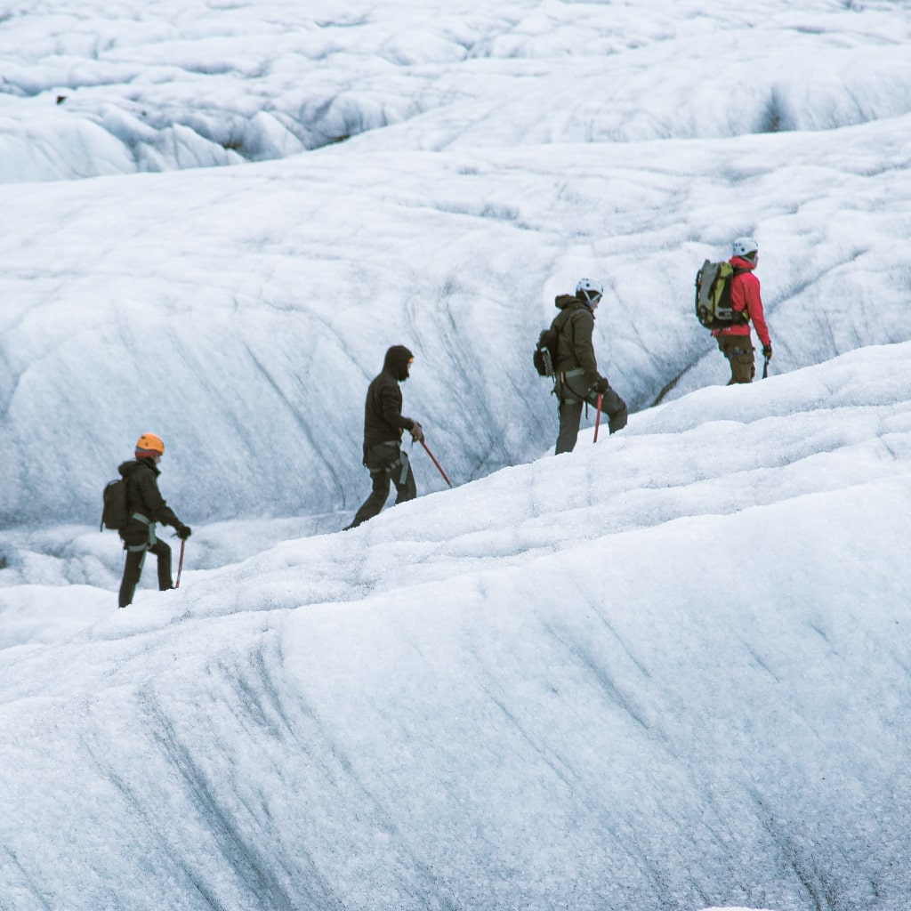 Hikers climbing ice rock.