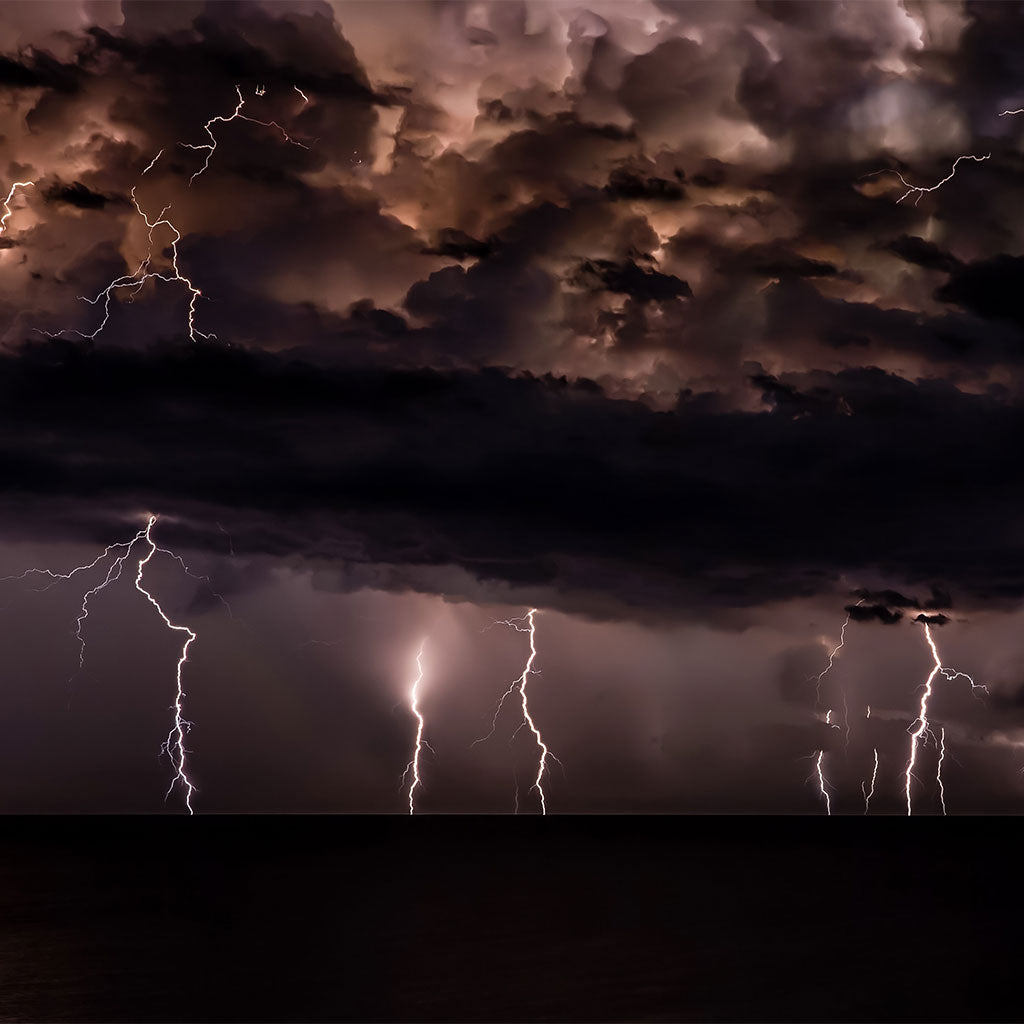 multiple lightning strikes through dark sky