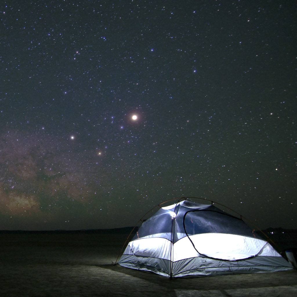 Camping tent under the starry night sky.