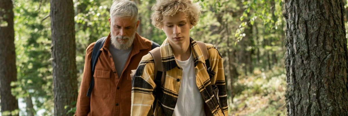 Father teaching survival skills to his son while on a hike.