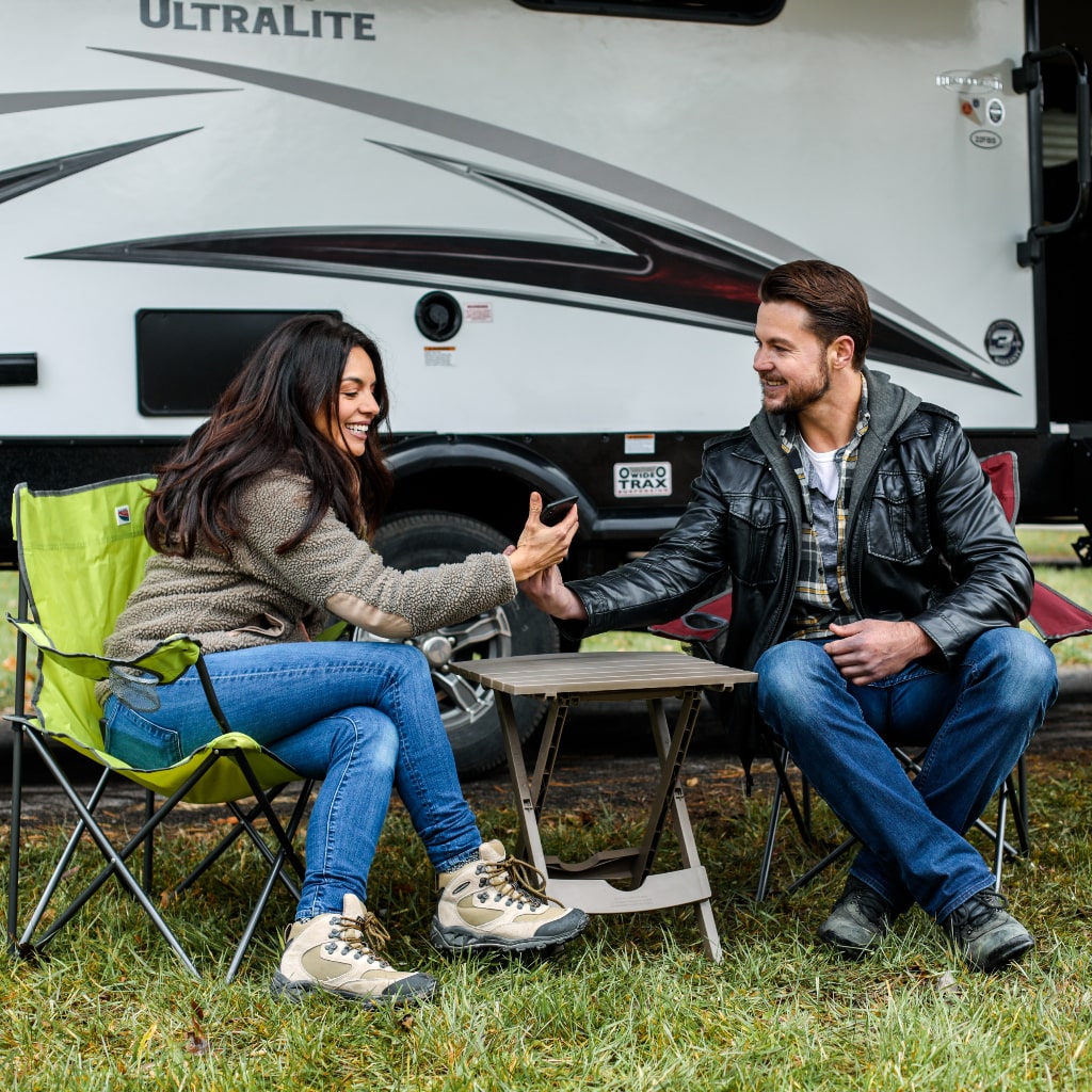 RV couple using app on smartphone.