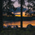 Three people camping by lake at sunset
