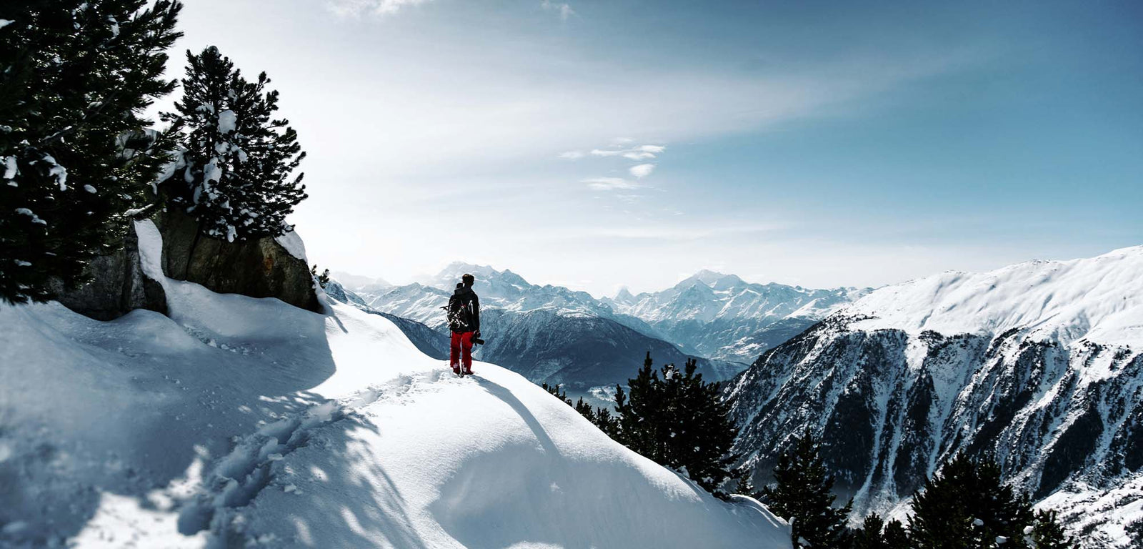 Winter backpacker on snowy mountain slope summit.