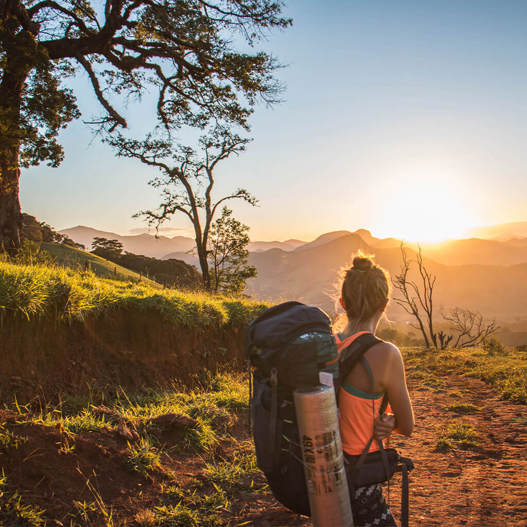 woman backpacking down mountain trail