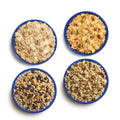 Aerial view of prepared freeze-dried meals in blue camping bowls. Meals shown are Biscuits & Gravy, Breakfast Skillet, Granola with Milk & Blueberries, and Beef Stroganoff with Noodles.