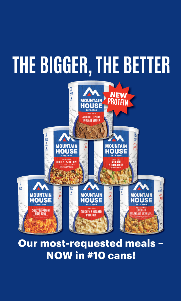 Six Mountain House #10 cans stacked in a pyramid over a blue background. Text: "The Bigger, The Better. Our most-requested meals — NOW in #10 Cans." A starburst near the Andouille Pork Sausage Slices can says "New Protein."