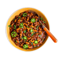 Aerial view of prepared Mountain House Chili Mac in a yellow bowl with an orange-colored fork.