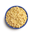 Blue camping bowl filled with yellow scrambled eggs on a white background