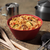 Bowl of Mountain House Kung Pao Chicken sitting on countertop with other camping supplies in the background.