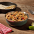 Mountain House Chicken Fajita Bowl in a metal camping bowl, with a lime and a cast iron skillet of tortillas nearby.