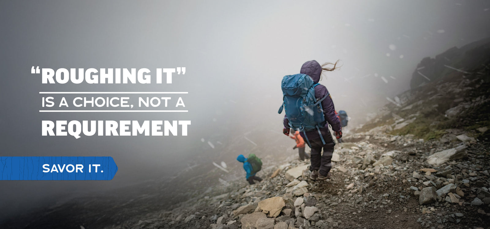 Hikers on a misty mountain trail with text: “Roughing it is a choice, not a requirement—savor it."