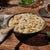 Bowl of creamy chicken and dumplings with vegetables on a wooden table