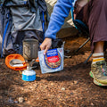 Person grabbing pouch of Chicken Fajita Bowl at campsite.