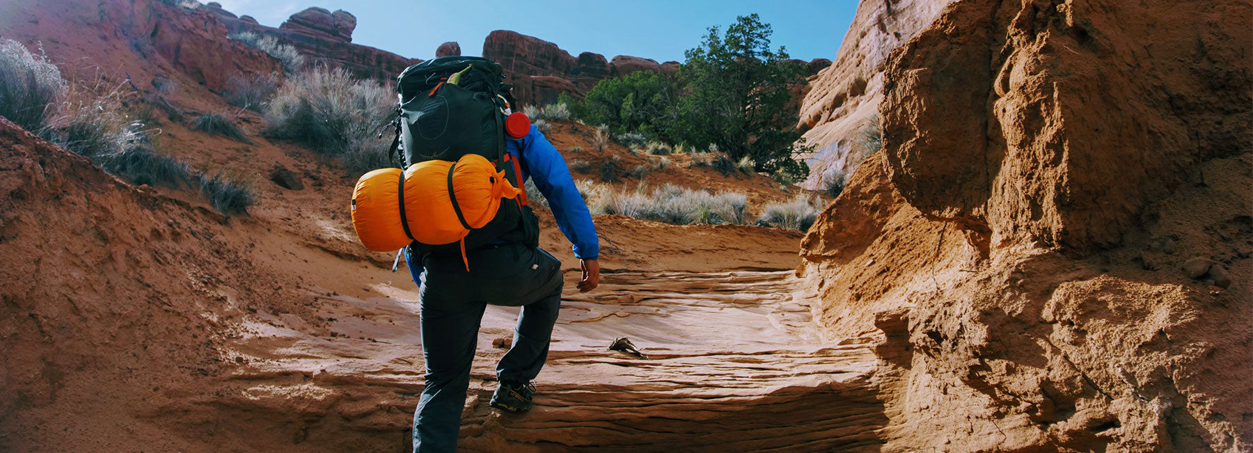 Guy backpacking up canyon during the daytime