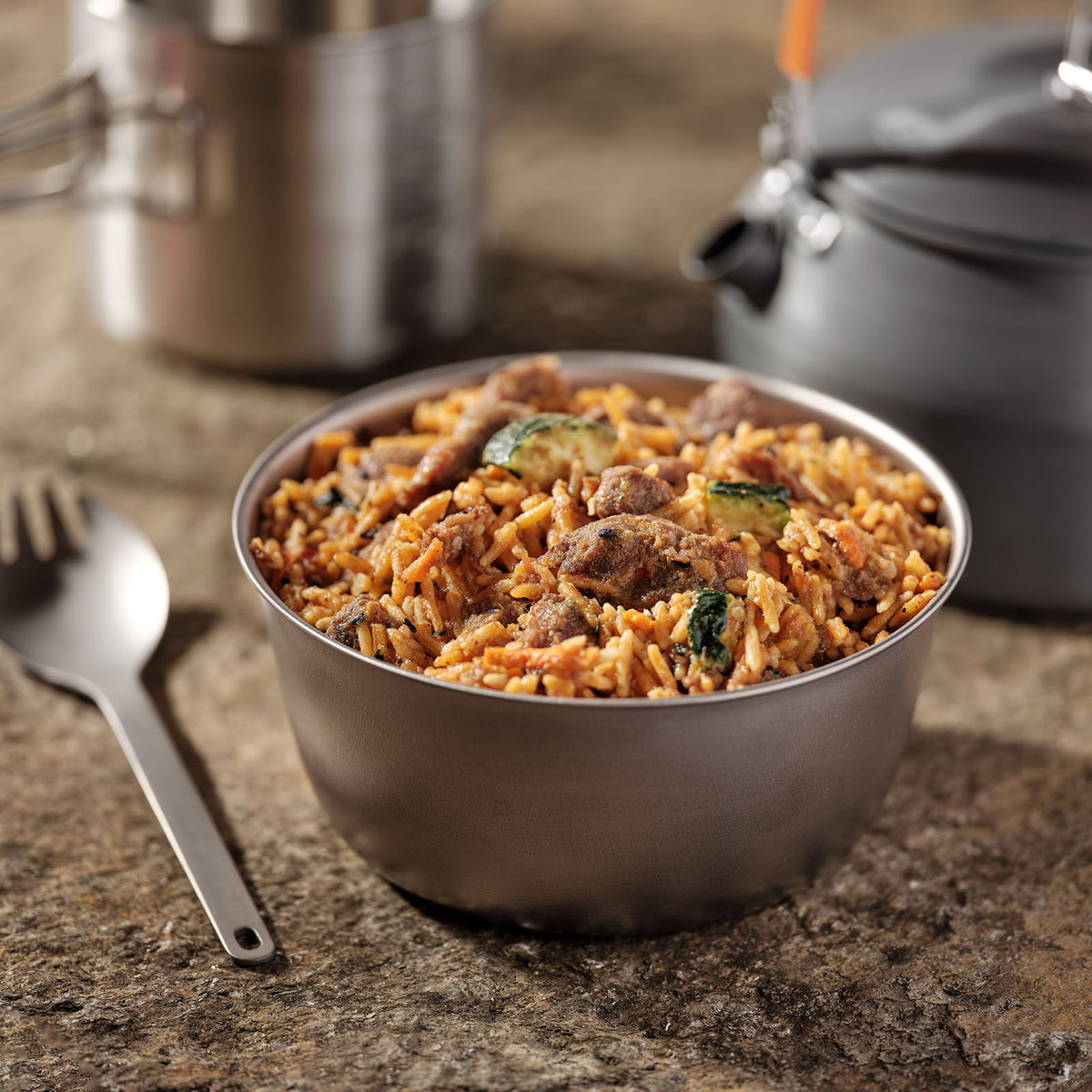 Korean Inspired Beef Bulgogi in a silver camping bowl next to other camping equipment.