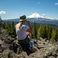 Girl eating Mint Chocolate Chip Ice Cream Sandwich while looking out at a mountain view.