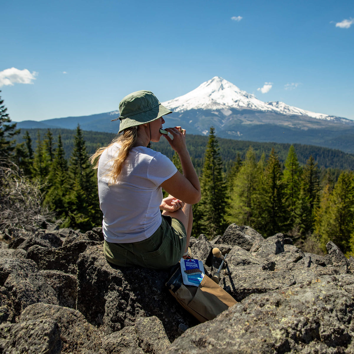 Girl eating Mint Chocolate Chip Ice Cream Sandwich while looking out at a mountain view.